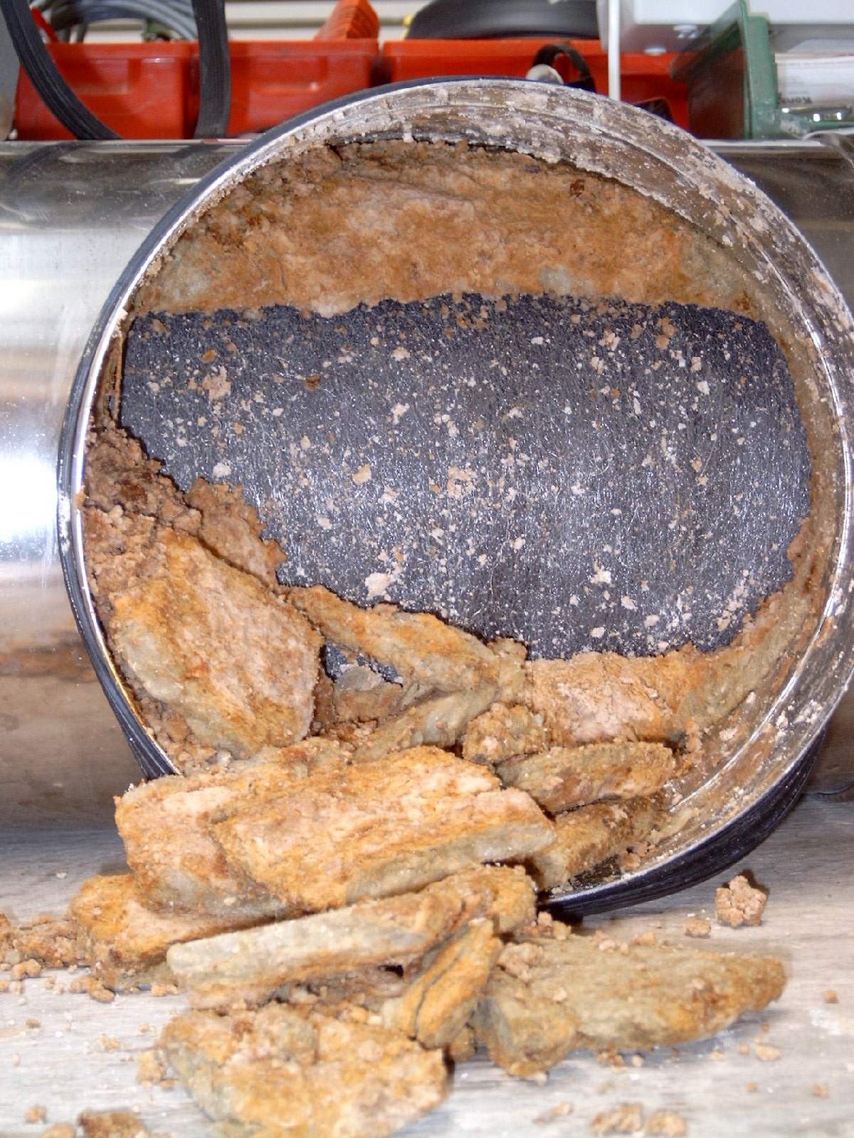 Beschädigte und aufgelöste Mineralfaserfüllung eines Schalldämpfers Beschädigte und aufgelöste Mineralfaserfüllung eines Schalldämpfers