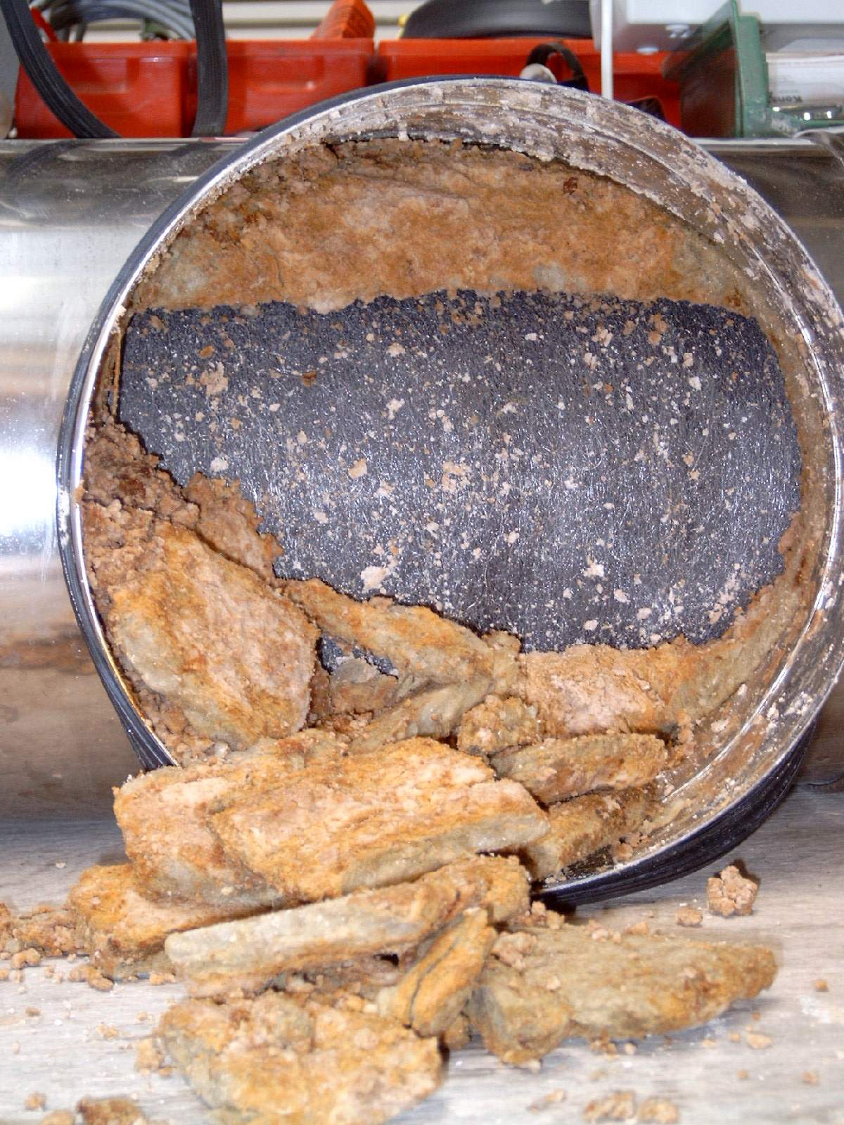 Beschädigte und aufgelöste Mineralfaserfüllung eines Schalldämpfers Beschädigte und aufgelöste Mineralfaserfüllung eines Schalldämpfers